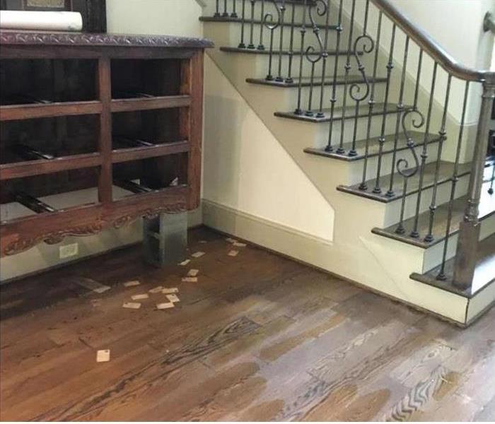water damaged floors and walls by stairway