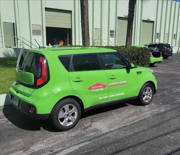 green SERVPRO car sitting in front of a warehouse